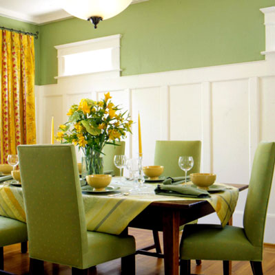 A green themed dining room with flat panel wainscoting