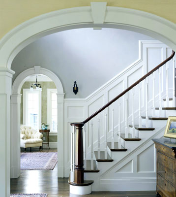 Stairs with wainscoting as seen through an archway