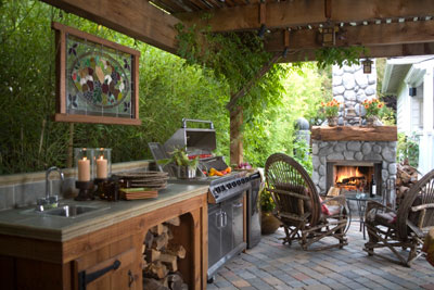 A covered outdoor kitchen with a fireplace