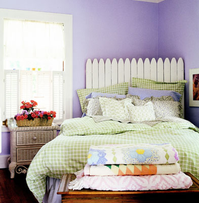 A summer style room with purple walls and a white picket fence headboard