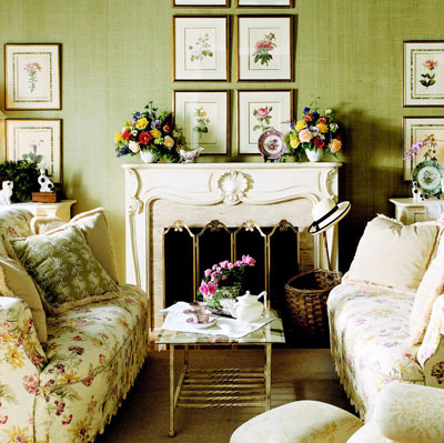 A cottage style fireplace with pictures hanging over the mantle