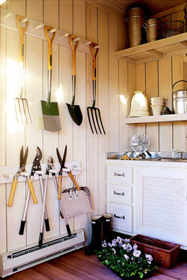 Several gardening tools hanging on a wall