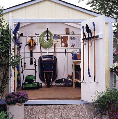 Shed door open to show all of the different gardening tools in the shed