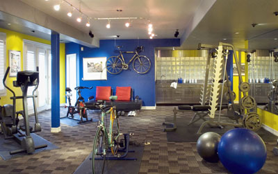 A workout room complete with weights, stationary bikes, and an eliptical