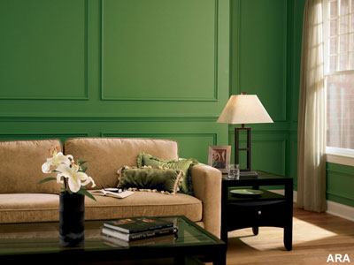 A living room couch with a forrest green painted wall