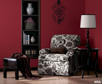 A sitting area with a magenta painted wall and an inset bookshelf