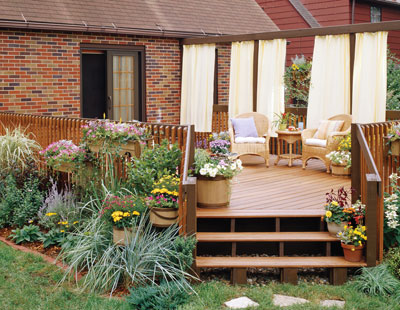 A deck attached to the house with steps down into the yard