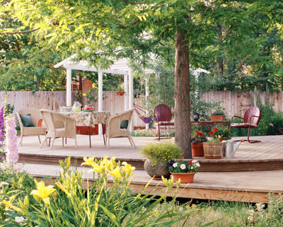 Large deck with an outdoor dining set and a pergola in the background